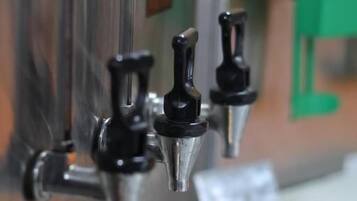 A coffee machine with a metal exterior and a green counter.