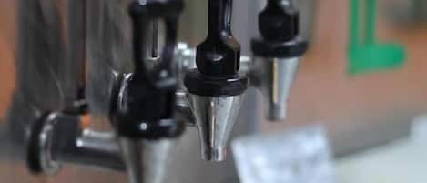 A coffee machine with a metal exterior and a green counter.