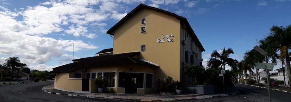 Un edificio de dos pisos con un letrero que dice 'HOTEL Sol Sol'.