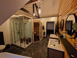 Un bagno moderno con cabina doccia in vetro, vasca freestanding e un mobile vanitario con specchio.