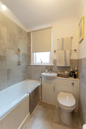 Un bagno moderno con vasca, lavabo e servizi igienici.