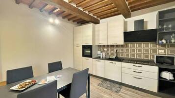 Una cocina compacta con una mesa de comedor, sillas y un microondas.
