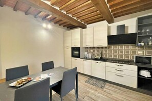 Una cocina compacta con una mesa de comedor, sillas y un microondas.