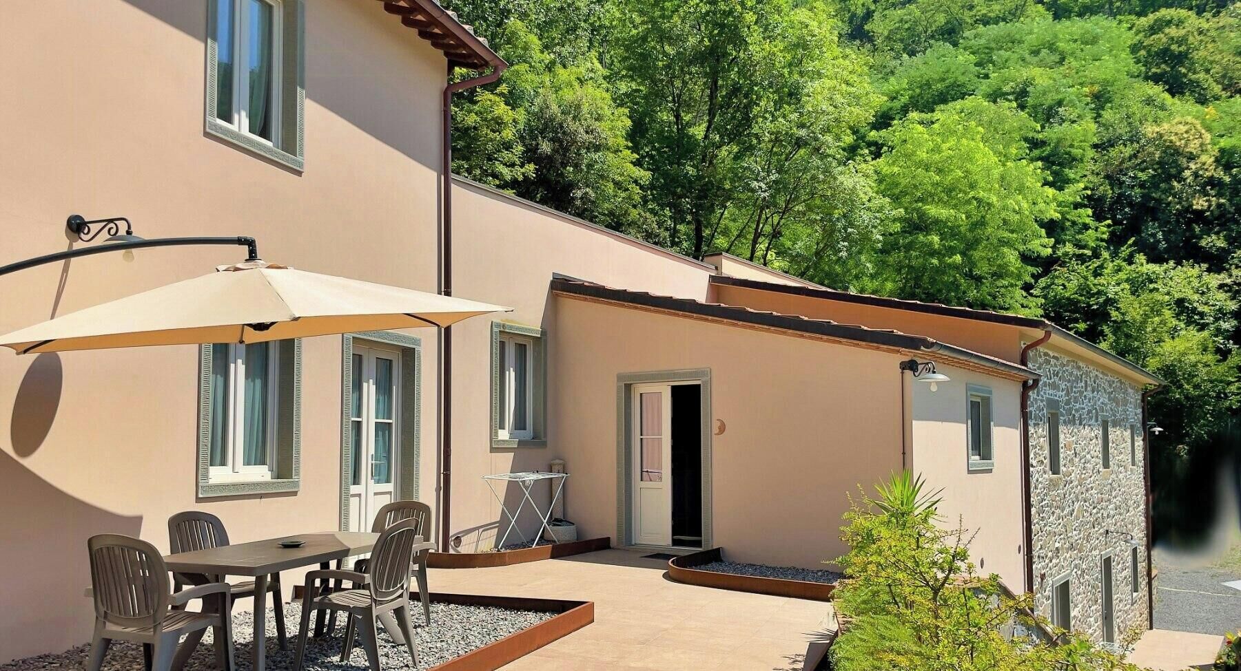 Un bâtiment doté d’un patio, d’un espace extérieur aménagé pour s’asseoir et d’une petite entrée.