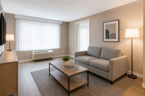 Ein modernes Wohnzimmer mit einer Couch, einem Couchtisch und einem Fernseher.