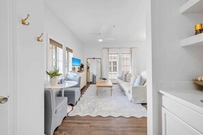 A modern living room with a sofa, coffee table, and a TV. - Dream Sweet by Stay on 30a (Seacrest Beach)