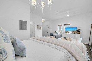 A bedroom with a large bed, a desk, and a television. - Dream Sweet by Stay on 30a (Seacrest Beach)