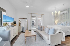 A modern bedroom with a bed, sofa, and a dining area. - Dream Sweet by Stay on 30a (Seacrest Beach)