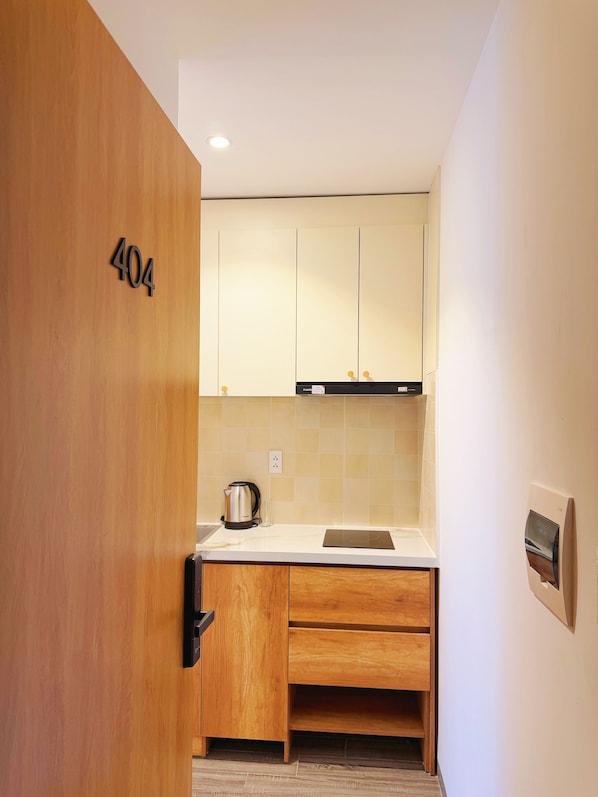 Una cocina moderna con armarios de madera, una encimera y un hervidor.