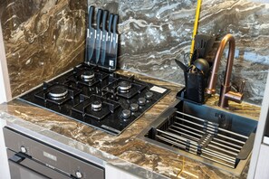 A kitchen with a Bosch gas stove, a marble countertop, and a copper faucet. - StayShort - Cozy Studio in Jumeirah Garden City with Balcony Sleeps 2 (Jumeirah Garden City)