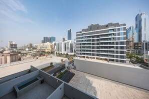 A modern high-rise building with multiple balconies and a rooftop terrace. - StayShort - Cozy Studio in Jumeirah Garden City with Balcony Sleeps 2 (Jumeirah Garden City)