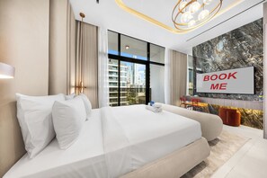 A modern hotel room with a large bed, a TV, and a city view. - StayShort - Cozy Studio in Jumeirah Garden City with Balcony Sleeps 2 (Jumeirah Garden City)