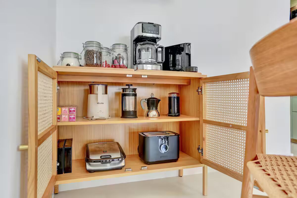 A kitchen with a coffee maker, toaster, and storage jars.