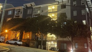 A multi-story building with balconies, a parking area, and a street lamp. - City Views. Luxury Vibes. West Midtown Living. (Atlanta)