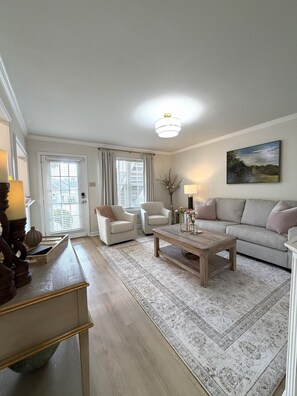 A living room with a sofa, two armchairs, a coffee table, and a painting on the wall. - Cozy 2-bedroom, beautifully decorated, great location. (Oxford)