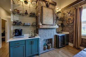 A kitchen with a stone wall, a map, and a whiskey house sign. - The Full Proof Penthouse in Downtown Bardstown - Walking to Restaurants & Shops! (Bardstown)