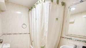 Un baño con inodoro, bañera y lavabo.
