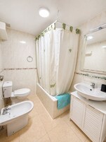 Un baño con inodoro, bañera y lavabo.