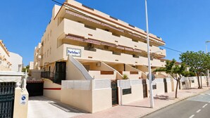 Un edificio de varios pisos con un letrero que indica 'Portofino V' y una entrada con portón.