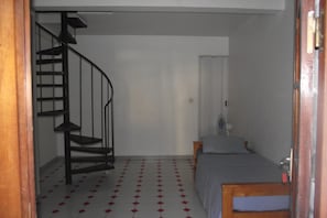 Una habitació amb una escala espirall i un llit, a més d'una taula petita.