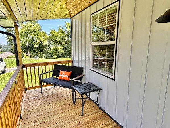A wooden deck with a bench and a window.