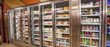 A row of refrigerated display cases in a hotel lobby, containing various food items and beverages.