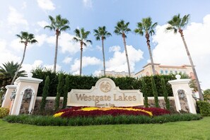 A sign for Westgate Lakes Resort & Spa with a landscaped garden and palm trees. - Spacious Apt with Balcony or Terrace and Jacuzzi bath 15mins from Universal (Orlando)