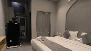 Quarto com cama, mesas de cabeceira, ventoinha no teto e ar condicionado instalado.