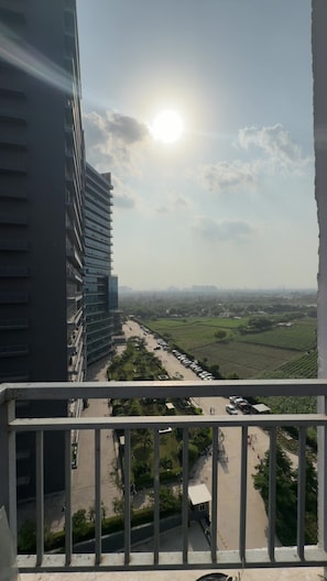 A high-rise building with a view of a green landscape and a clear sky.