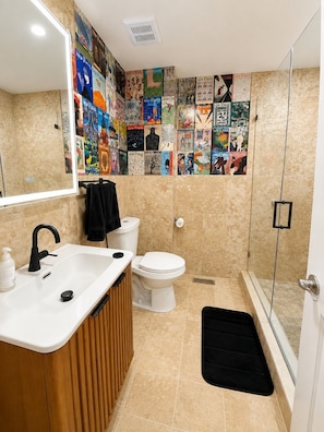 Ein Badezimmer mit einem weißen Waschbecken, einer Toilette und einer Duschkabine.