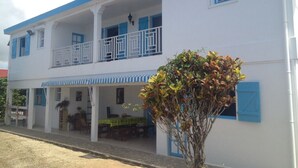 A two-story building with a balcony, a covered porch, and a dining area.