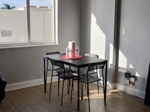 A dining area with a table, chairs, and a window. - Cozy studio in Sunny Isles Beach with AC and fitness room STR-02177 CND2333473 (Sunny Isles Beach)