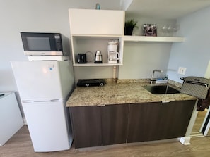 A compact kitchen with a refrigerator, microwave, coffee maker, and a sink. - Cozy studio in Sunny Isles Beach with AC and fitness room STR-02177 CND2333473 (Sunny Isles Beach)