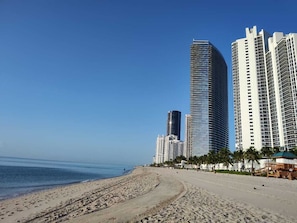 A beachfront with high-rise buildings, sandy beach, and palm trees. - Cozy studio in Sunny Isles Beach with AC and fitness room STR-02177 CND2333473 (Sunny Isles Beach)