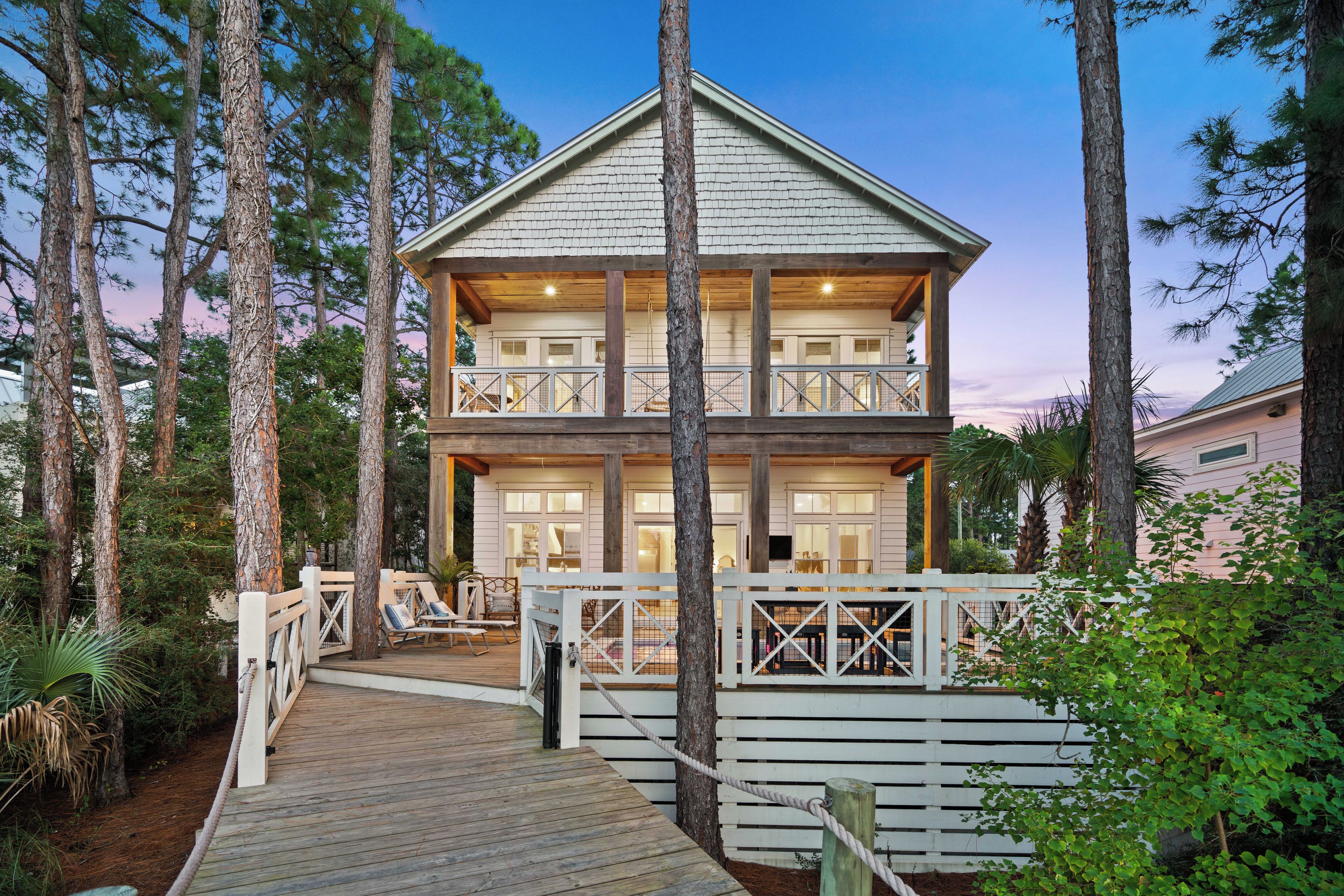 A two-story building with a wooden deck and a white fence.