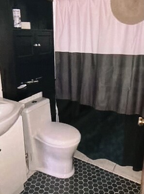 Een badkamer met toilet, wastafel en douchehoek.