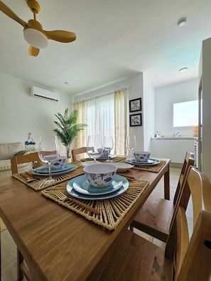 A dining area with a wooden table, woven placemats, and blue and white dinnerware. - Laguna Beach 306 Stylish Apartment- Just 3 Minutes Walking to Playa Dominicus (Dominicus)