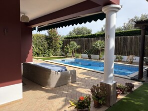 A covered outdoor area with a swimming pool, seating, and potted plants. - Alvor Sun Villa | Private Pool | 4 Bedrooms (Alvor)