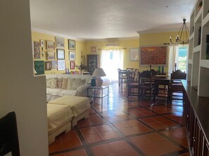Un salon comprenant un canapé, une table à manger, des chaises et un coin cuisine.