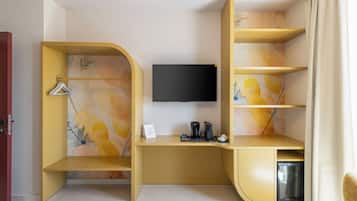 Una habitación moderna con un escritorio curvo, un televisor de pantalla plana y una estantería empotrada.