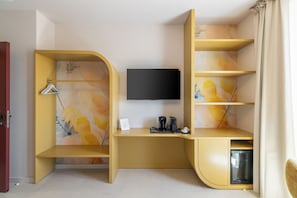 Una habitación moderna con un escritorio curvo, un televisor de pantalla plana y una estantería empotrada.