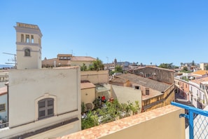 Vista de un paisaje urbano con edificios, cielo despejado y barandilla azul.