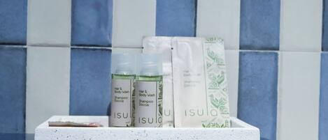 A set of toiletries on a white tray against a tiled wall.
