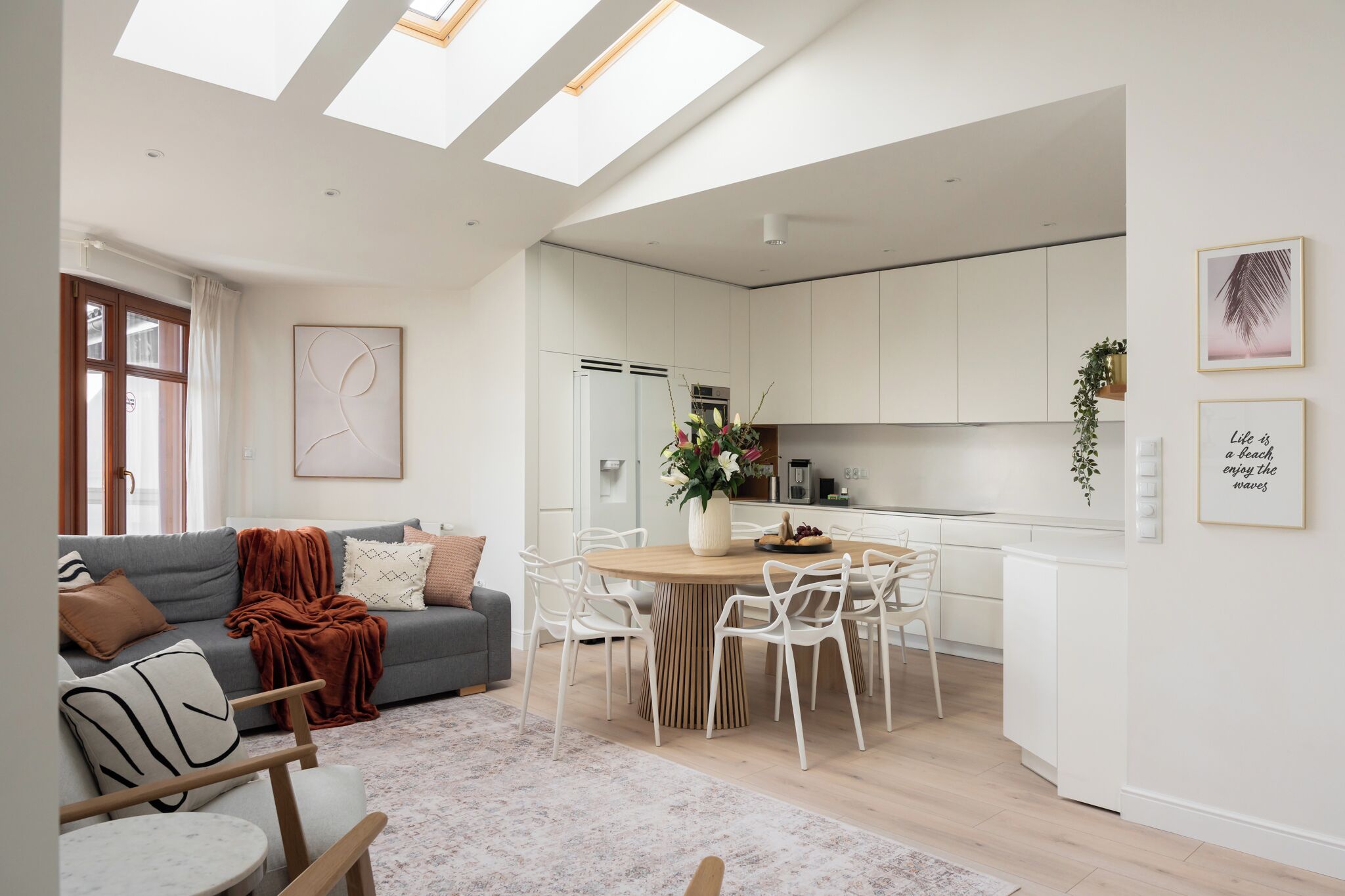 A modern apartment with a dining area, kitchen, and living room.
