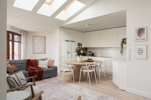A modern apartment with a dining area, kitchen, and living room. - Neptun Park comfort family apartment  (Gdańsk)