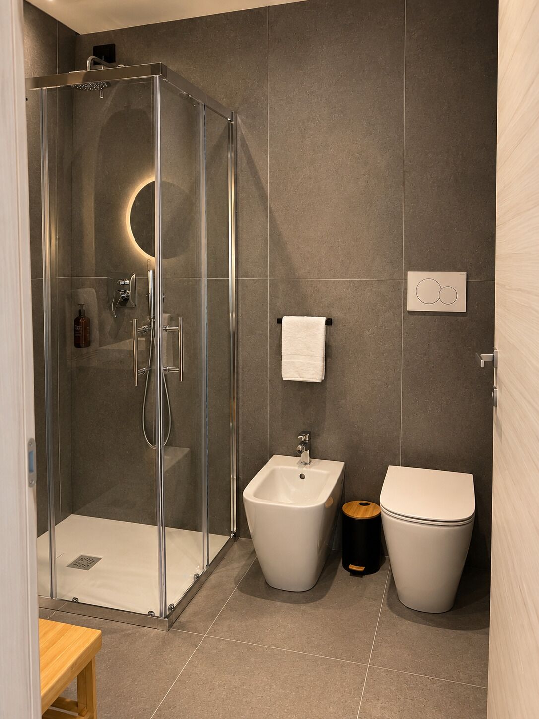 Ein modernes Badezimmer mit einer Duschkabine, einem Bidet und einer Toilette.