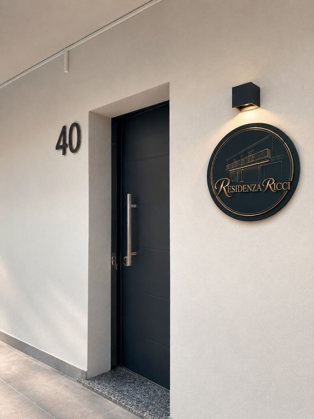 Vestíbulo moderno de un edificio con una puerta oscura, un cartel con el número '40' y un letrero circular que dice 'Residenza Ricci'.