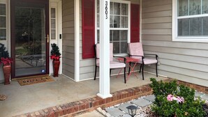 A house with a porch, a door with a glass panel, a mailbox, and a number '3605' on the wall.