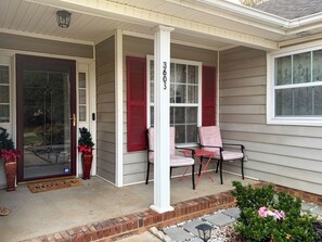 A house with a porch, a door with a glass panel, a mailbox, and a number '3605' on the wall.
