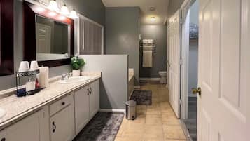 A modern bathroom with a vanity, mirror, and towel rack.